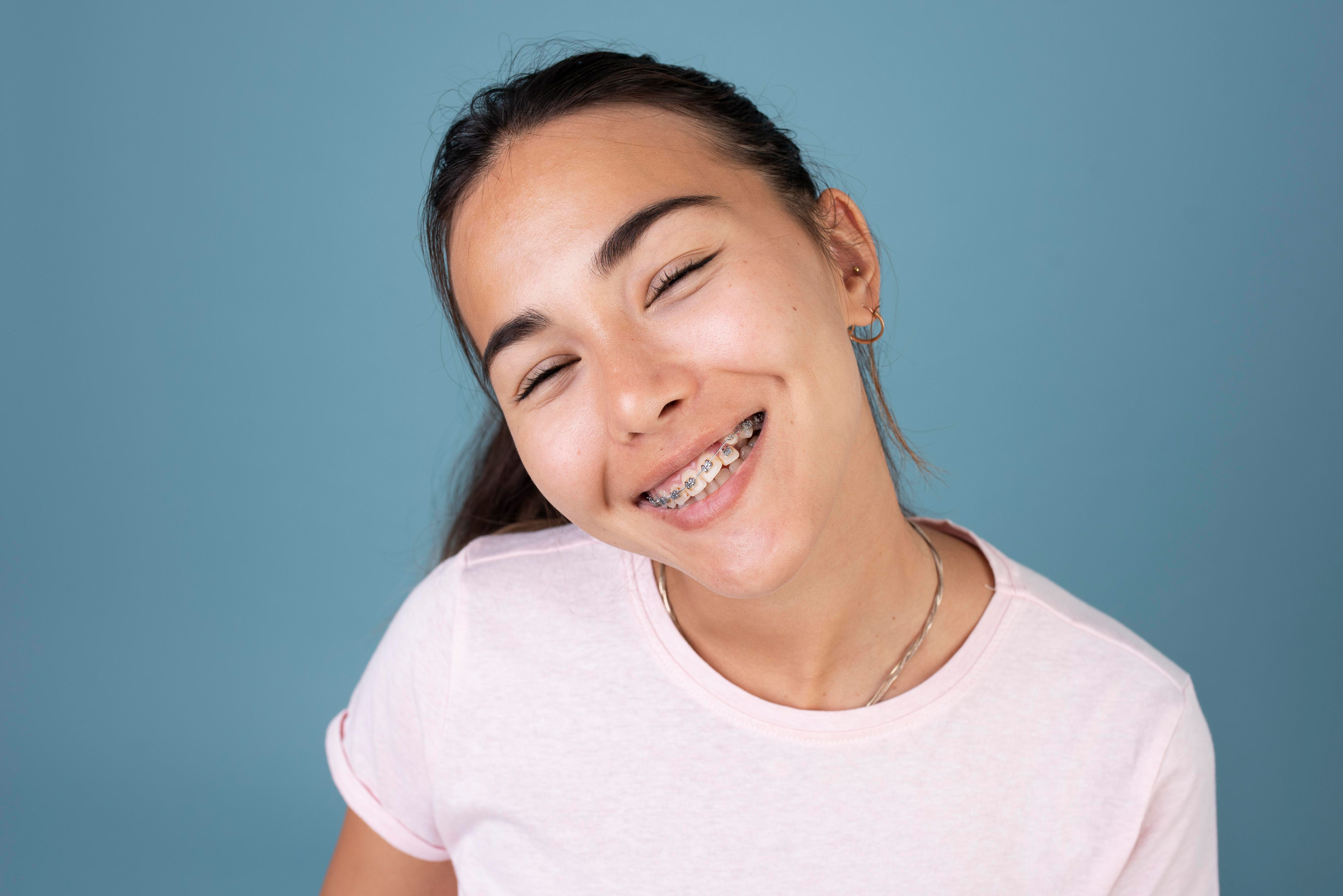 Girl smiling with metal braces for orthodontic treatment