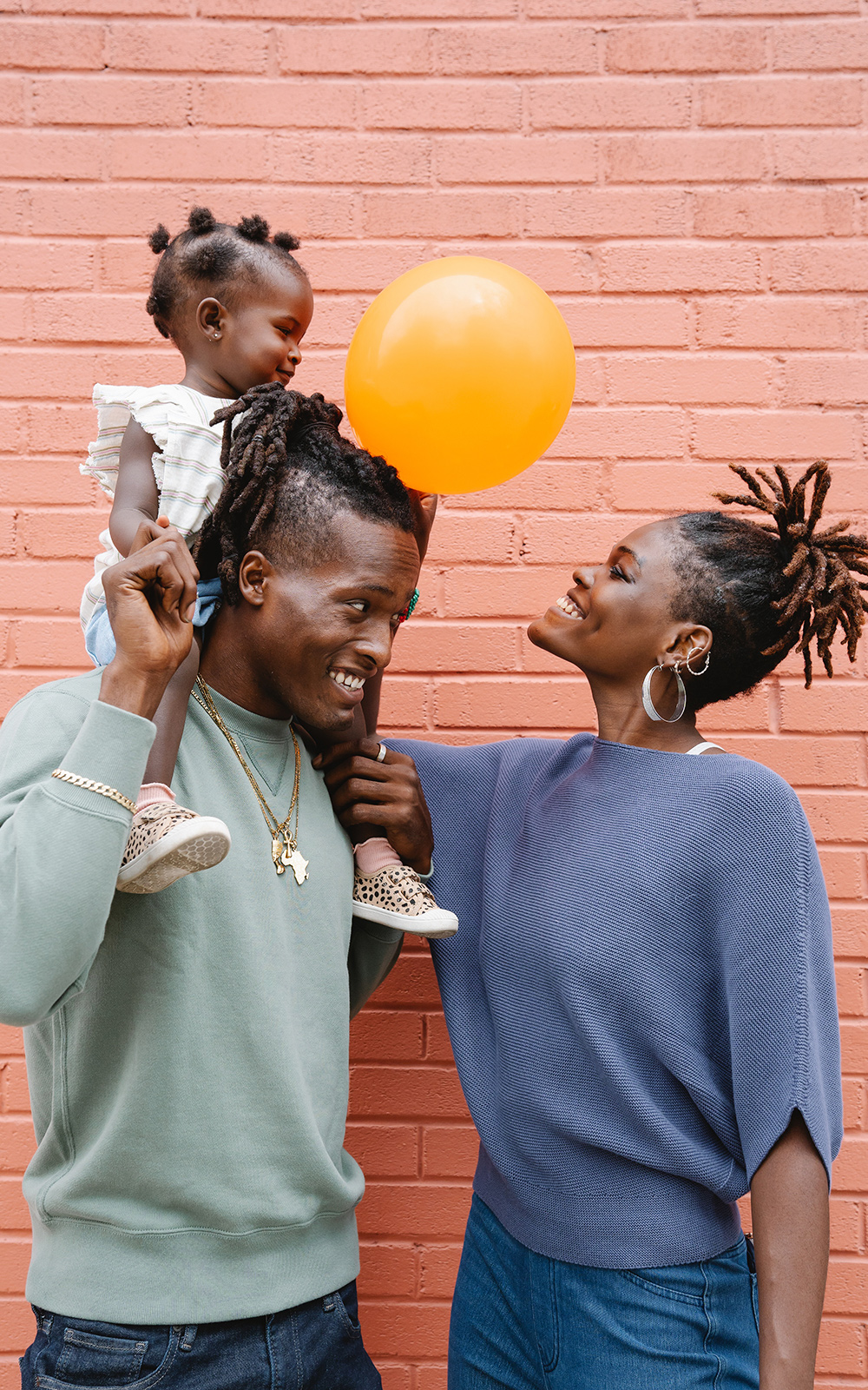 Family smiling with a little girl holding a balloon