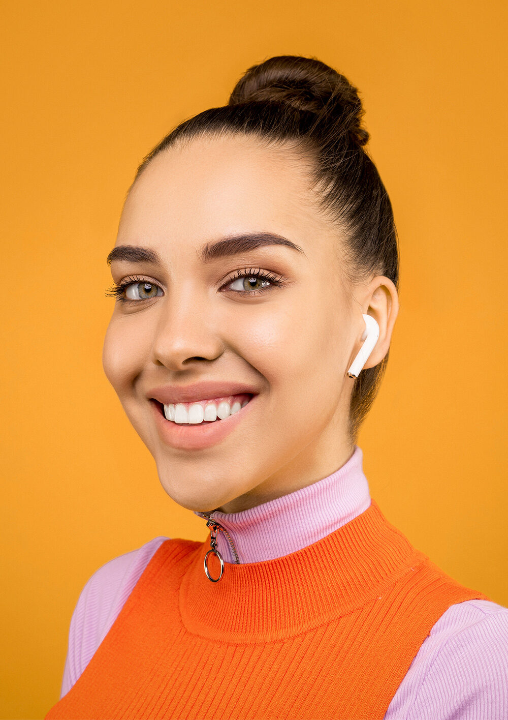 Girl in orange vest wearing wireless headphones