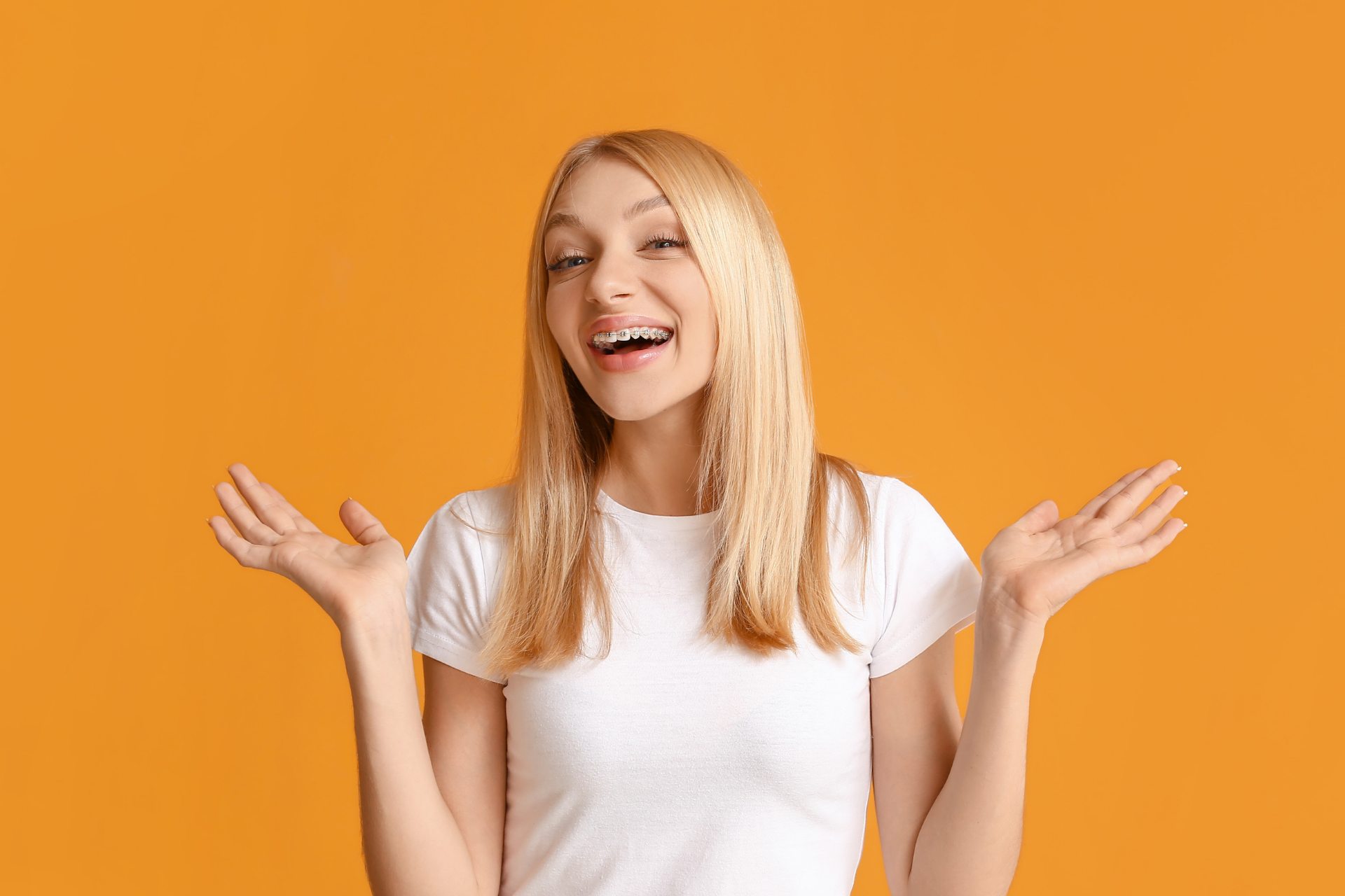 girl with braces on orange background