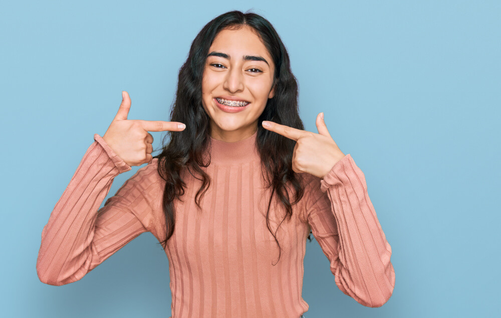 Pretty woman showing off braces to camera, West Cary Braces