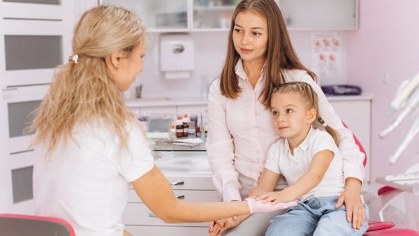 Mother and young child at a dental visit, the kind of family consult that starts phase 1 orthodontics