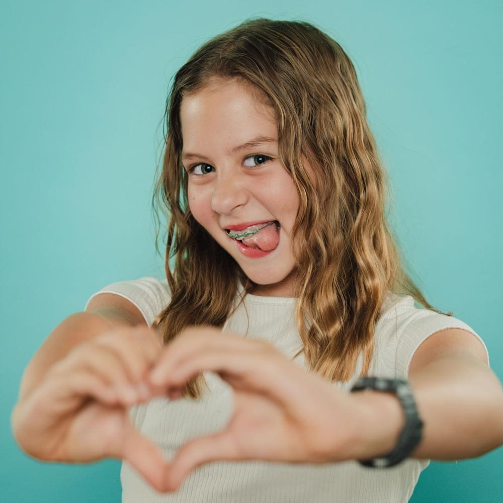 tooth-by-tooth-orthodontics-tooth-by-tooth-dr-patel-clear-aligners-girl-patient-smiling-heart-hands