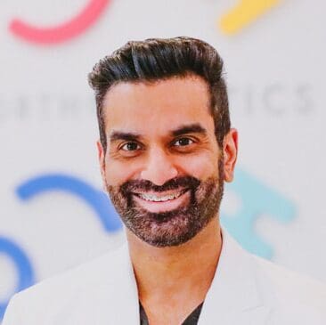 tooth-by-tooth-orthodontics-tooth-by-tooth-dr-patel-dr-nishant-patel-white-coat-smiling-closeup