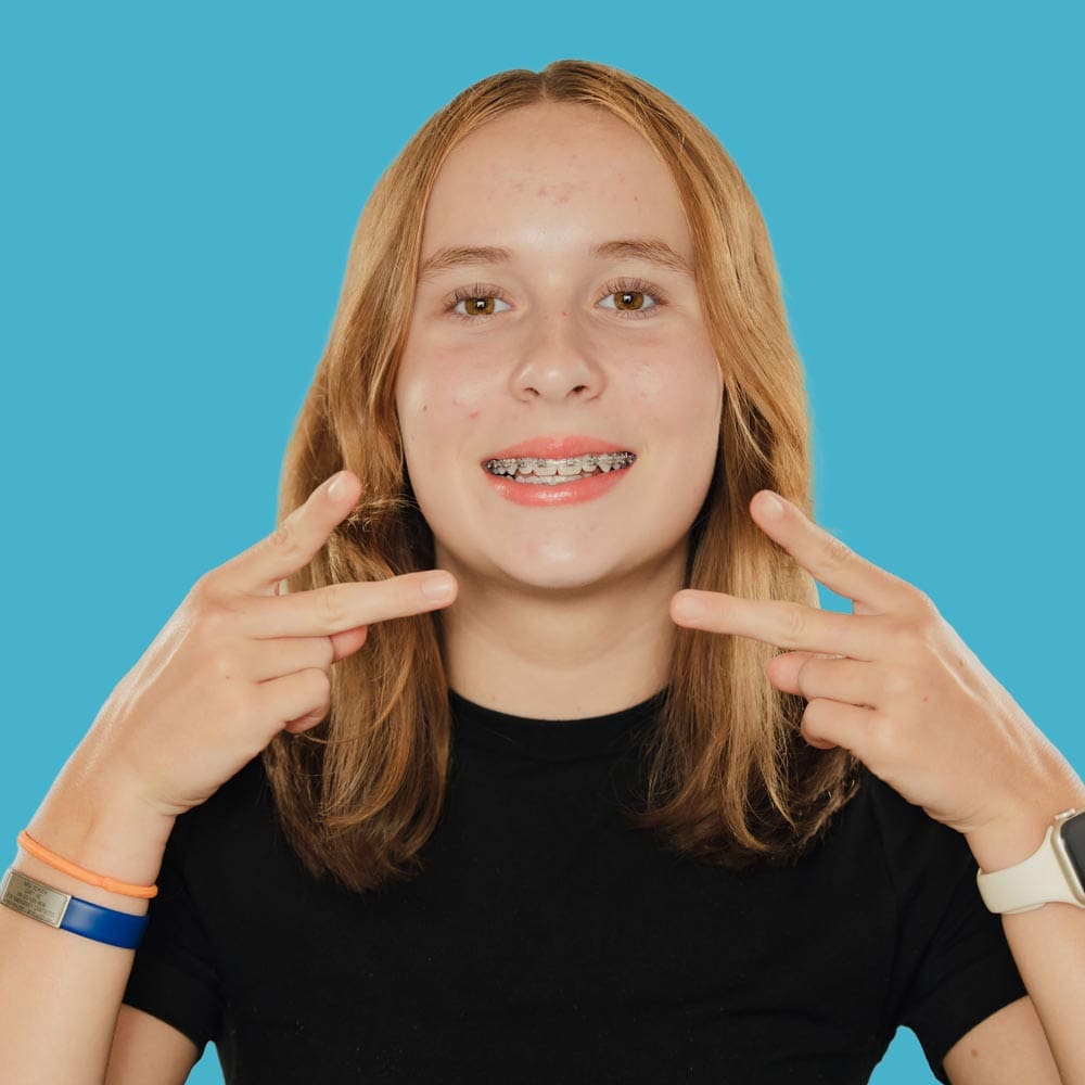 tooth-by-tooth-orthodontics-tooth-by-tooth-dr-patel-early-orthodontics-girl-patient-braces-peace-sign-edit-lite