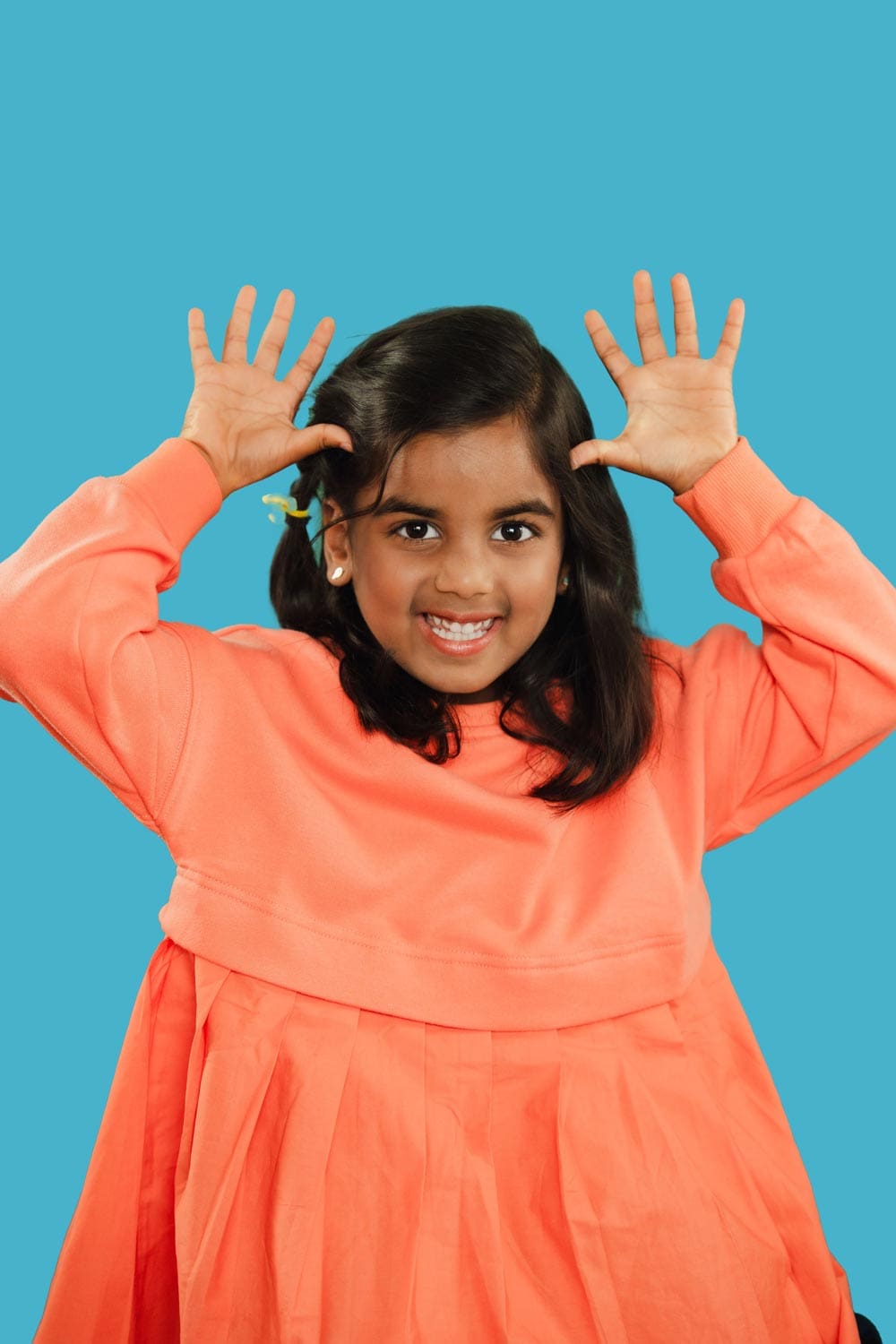 tooth-by-tooth-orthodontics-tooth-by-tooth-dr-patel-early-orthodontics-patel-daughter-patient-hands-waving-edit