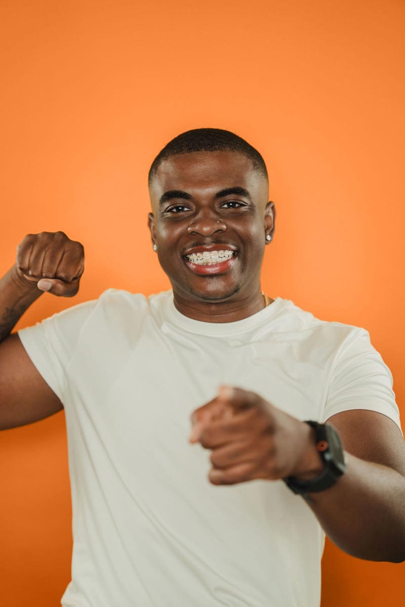 tooth-by-tooth-orthodontics-tooth-by-tooth-dr-patel-male-patient-smiling-pointing-teen-orthodontics-edit